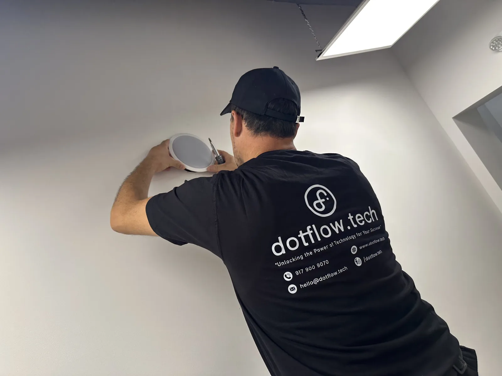 Technician installing a ceiling speaker