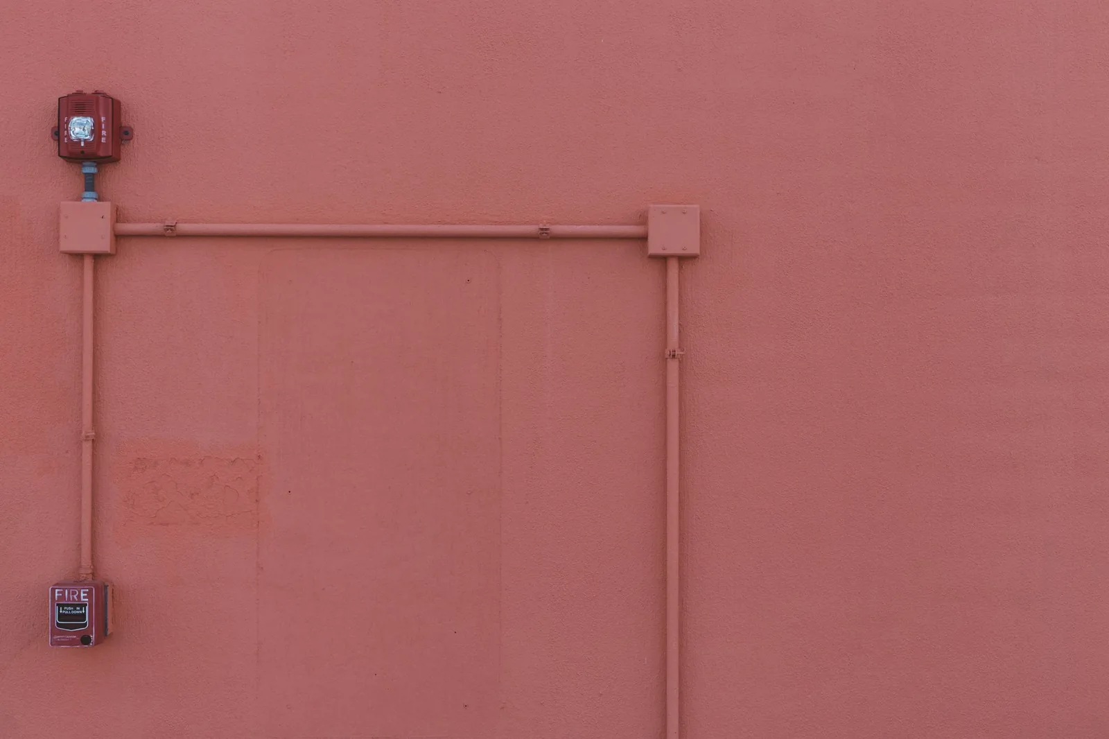 Fire alarm devices and conduit on a wall